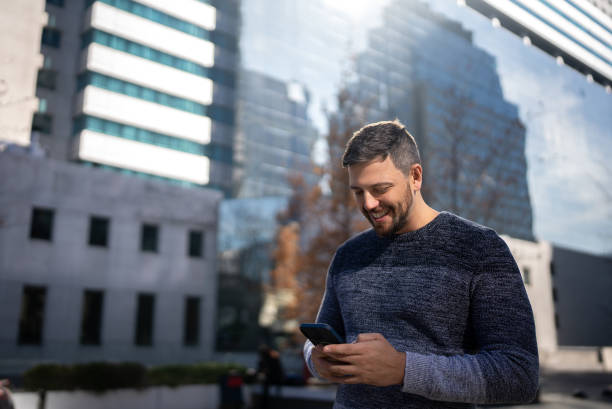 istock Mid adult man using mobile phone outdoors 1405265645