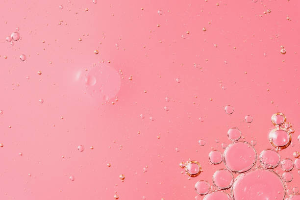 istock oil with bubbles on light pink coral monochrome background 1405265718
