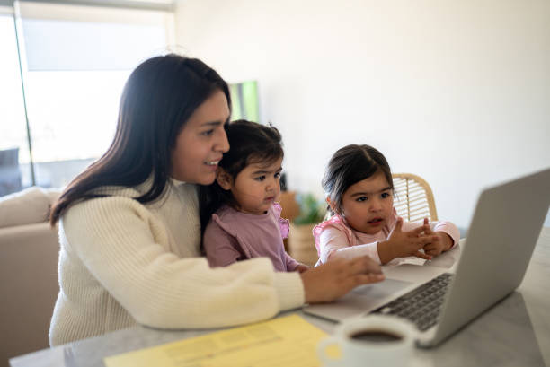 istock Mother using the laptop with daughters at home 1405265929