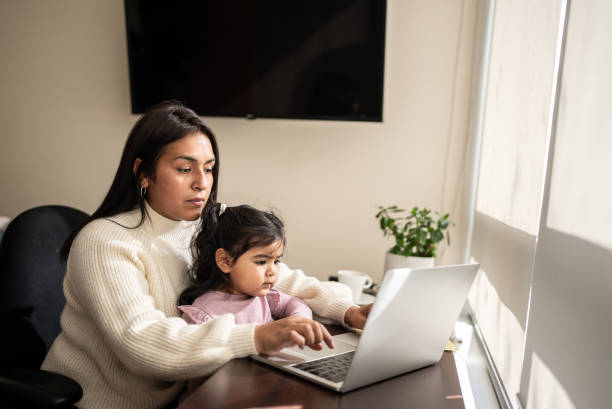 istock Mother using the laptop with daughter on her lap at home 1405265958