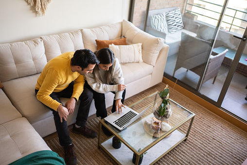 Couple using laptop at home