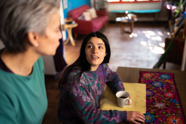 istock Daughter talking to mother while drinking coffee at home 1405267228