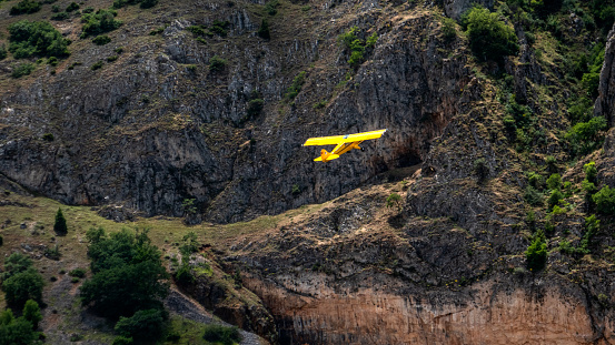 Small yellow plane flying close to the ground