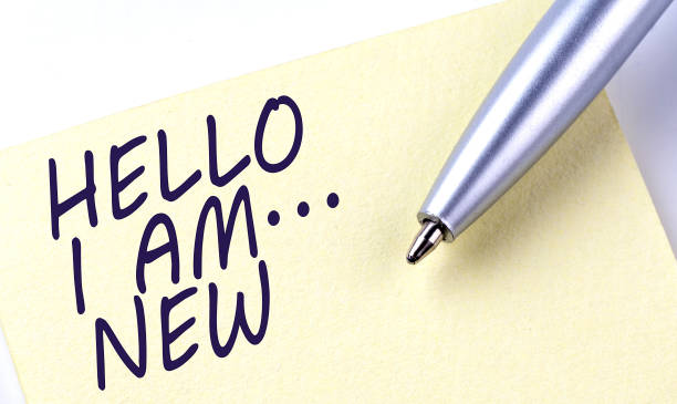 istock Sticky Note Message HELLO I AM NEW with pen on the white background 1405268347