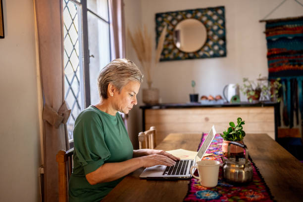 istock Mature woman using the laptop at home 1405268719
