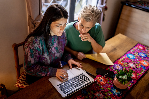 Mother and daughter using the laptop at home