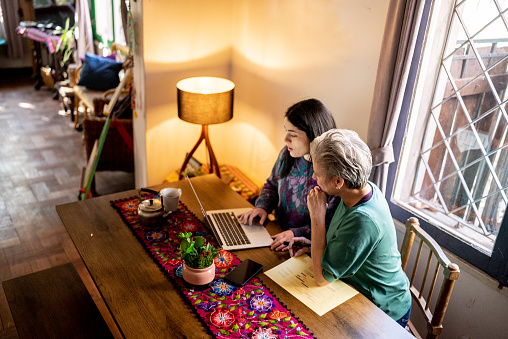 Mother and daughter using the laptop at home