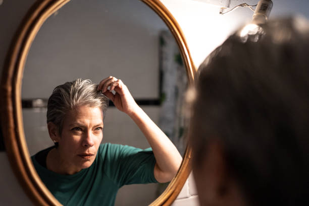 mulher madura se preparando em casa - cabelo grisalho - fotografias e filmes do acervo