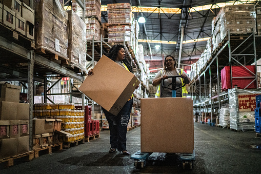 Warehouse worker using a hand truck carrying boxes