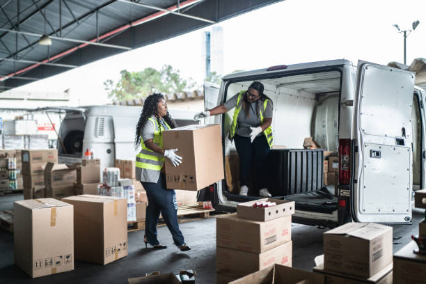 warehouse workers loading van with boxes - carregamento imagens e fotografias de stock