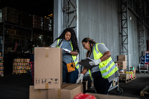 Warehouse workers checking boxes to deliver
