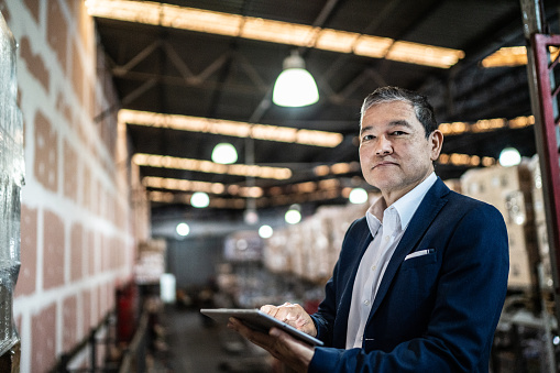 Portrait of a warehouse worker using digital tablet