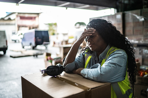 Tired or worried female warehouse worker