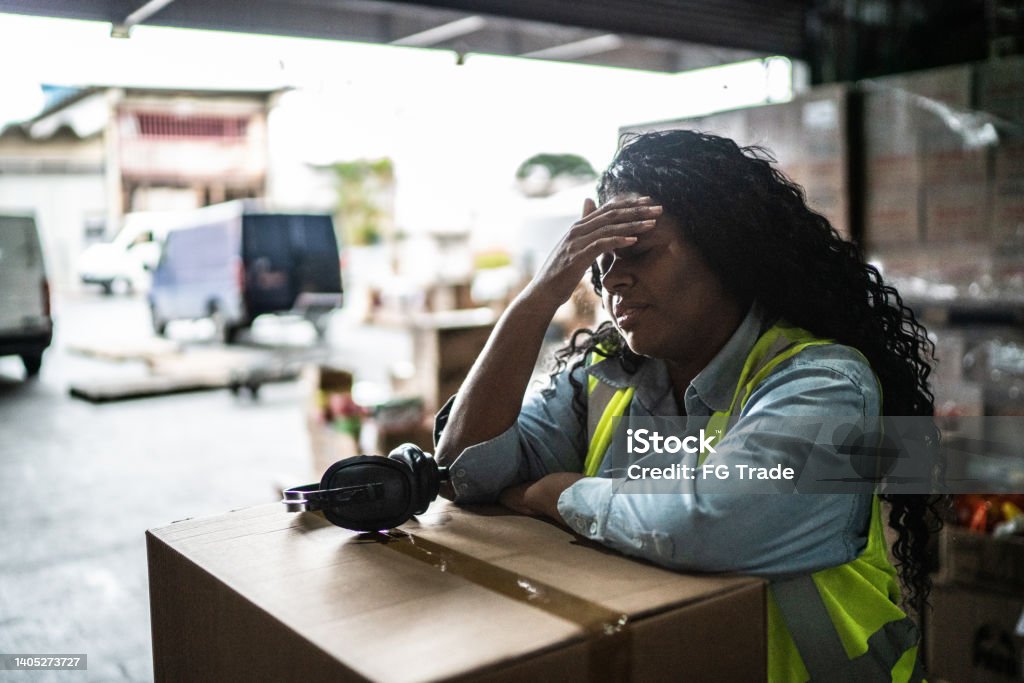 Tired or worried female warehouse worker Emotional Stress Stock Photo