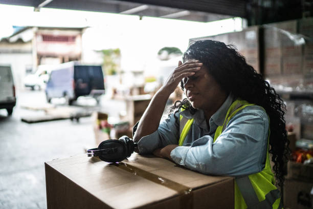 Tired or worried female warehouse worker Tired or worried female warehouse worker heat stress stock pictures, royalty-free photos & images