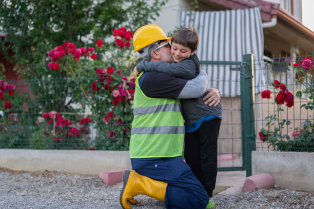 The engineer goes to night shift and says goodbye to your child at the entrance of the house. stock photo