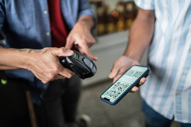 Young man scam QR code using mobile phone in a supermarket Young man scam QR code using mobile phone in a supermarket convenience store stock pictures, royalty-free photos & images