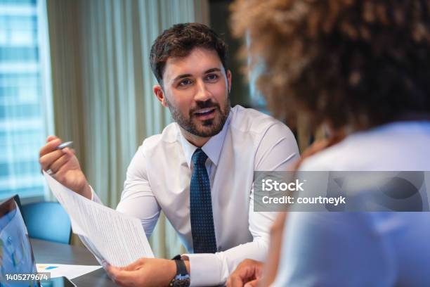 Business Man Talking To A Business Woman While Holding A Document He Is Happy And Smiling He Is Wearing A Tie Stock Photo - Download Image Now