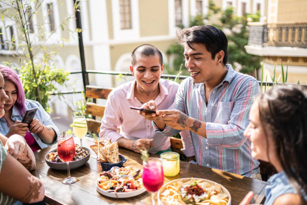 amigos se divertindo e filmando no celular em pub - foodie - fotografias e filmes do acervo