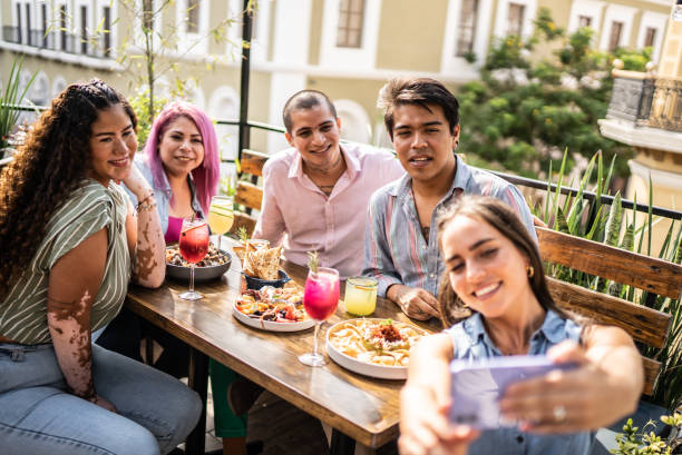 istock Friends taking a selfie using mobile phone at restaurant 1405279701