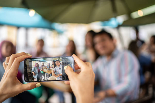 istock Friends taking a picture using mobile phone at a restaurant 1405280707