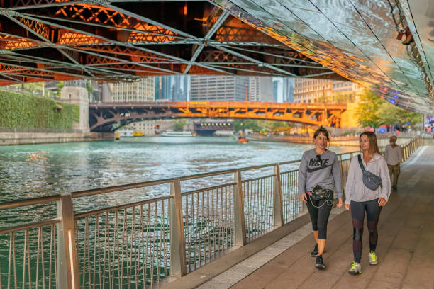 People walk along the famous Riverwalk park, under one of the draw bridges stock photo