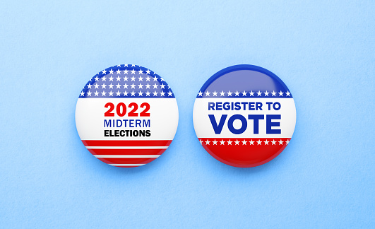 Register to vote and Midterm Election 2022 written badges sitting on blue background. Great use for election and voting concepts. 2022 US Midterm Election concept. Directly above.
