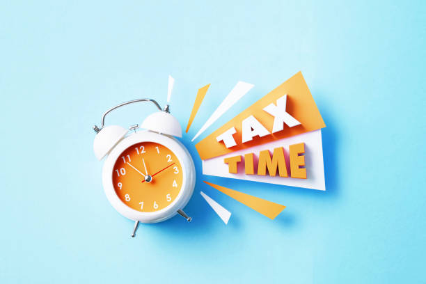 istock Tax Time Next To A White Alarm Clock On Blue Background 1405285073