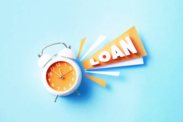 istock Loan Reads Next To A White Alarm Clock On Blue Background 1405285181