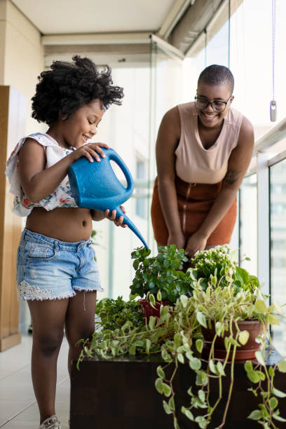 istock Sisters watering plants in balcony 1405285266