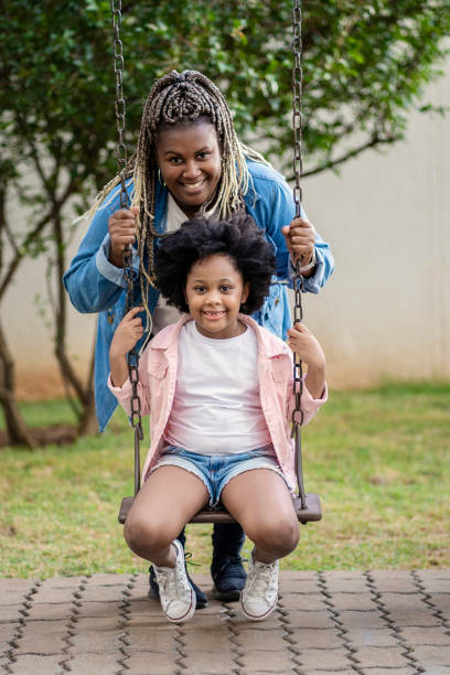 mujer y su sobrina en el patio de recreo - carousel merry go round child african descent fotografías e imágenes de stock