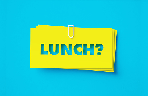 Lunch written cut out yellow adhesive notes sitting on turquoise background. Horizontal composition with copy space.