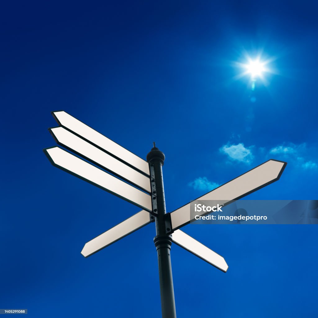 Blank directional signs over sunny blue sky Close up blank street name signs placard over clear blue sky Decisions Stock Photo