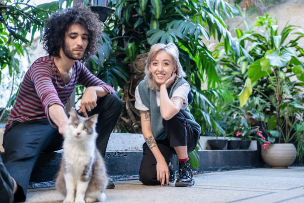 istock Non binary person and friend playing with cat 1405291718