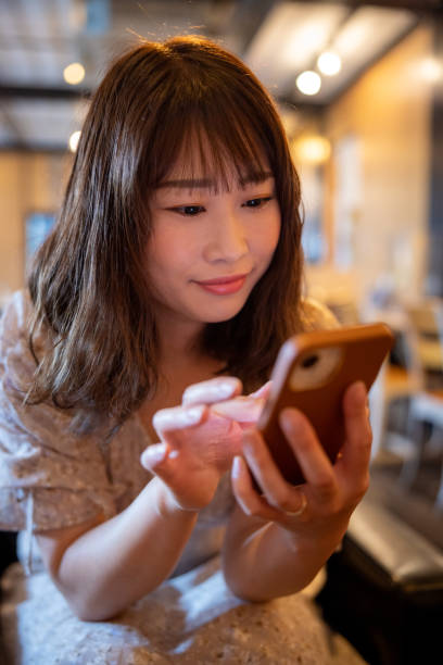 istock Beautiful woman using smart phone in cafe 1405291721