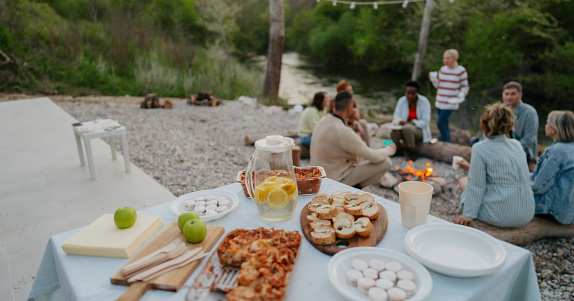 Photo of a served dinner table with different kinds of food and drinks; remote area dinner party food and drinks.