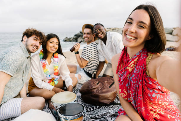 istock Young group of diverse friends taking selfie while relaxing at the beach 1405293195