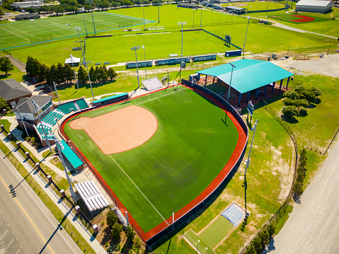 Baseball field at brightly lit fictitious outdoor stadium. Focus on foreground and shallow depth of field on background and copy space. Stadium created in Photoshop.