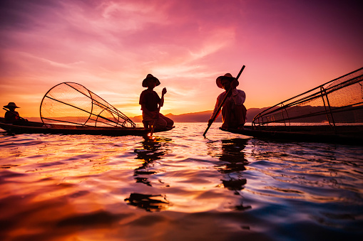 Fisherman posing during the sunset on Inle Lake. Leg-rowing fishermen on Inle Lake are a major tourist destination in Myanmar (Burma).