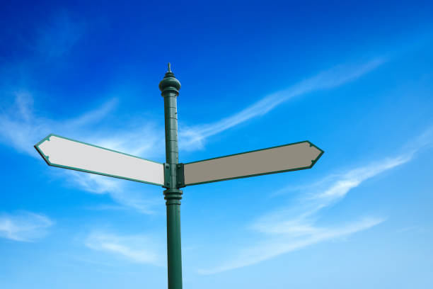istock Blank directional forked road sign over sunny blue sky 1405297555