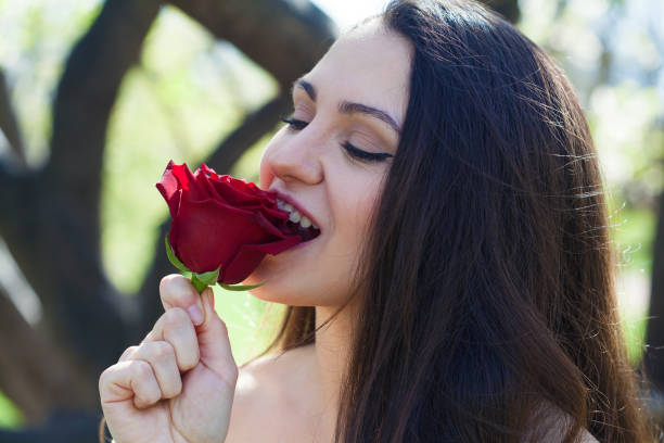 Young woman eating a rose