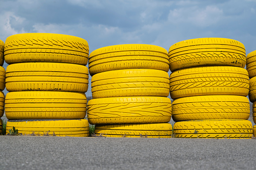 Shot on a yellow safety tire barrier.