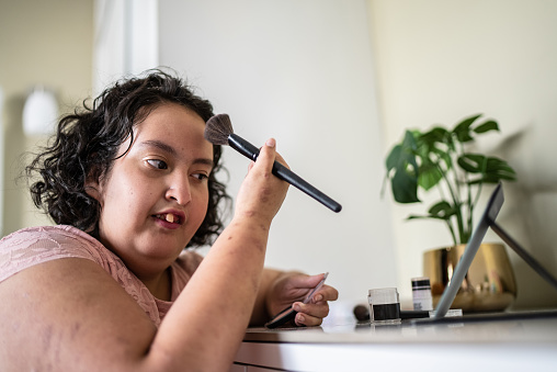 Psychomotor retardation girl doing her makeup at home
