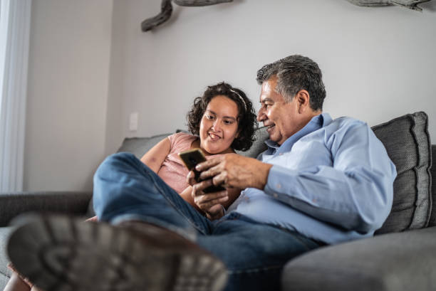 istock Father and psychomotor Intellectual disability daughter using mobile phone at home 1405303793