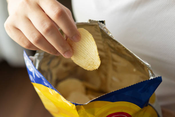 istock Hand hold potato chips with snack bag 1405308049
