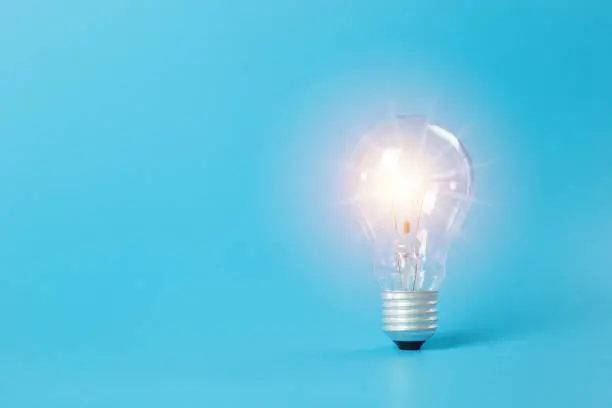 Photo of Economical energy concept. light bulb on blue background. electricity power innovation. Energy saving to reduce global warming.