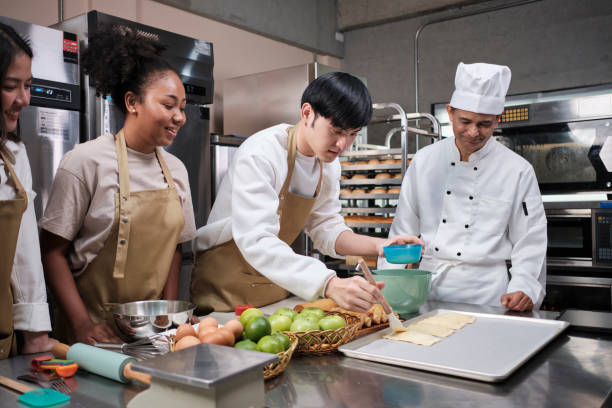 istock Senior chef teaches cooking students to prepare pastry dough for fruit pies. 1405330186