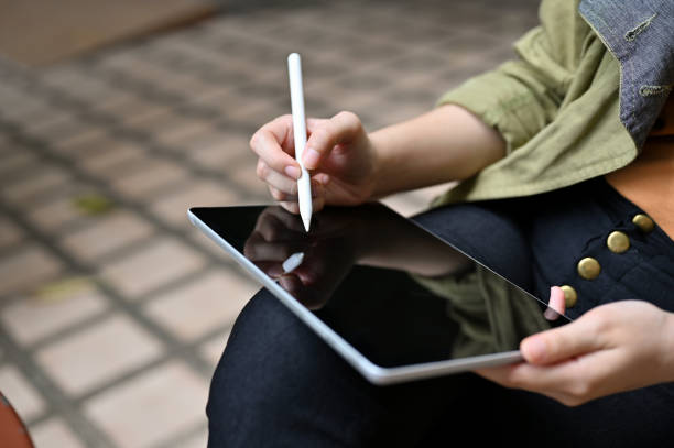 istock A female using a digital tablet touchpad, using stylus pen to design her graphic artwork. 1405330413
