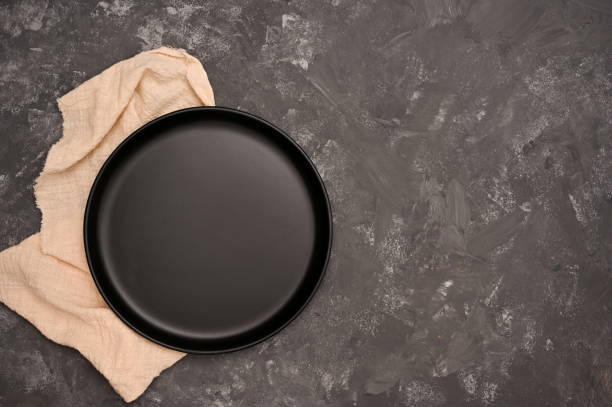istock Empty black ceramic plate mockup and copy space on stylish grey cement table. 1405330459