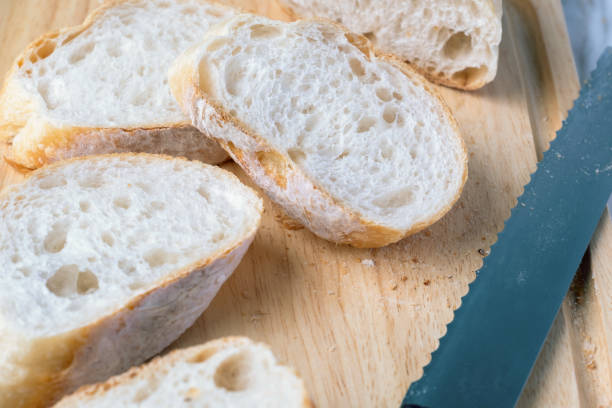 istock Fresh sliced baquette bread on wooden table. 1405331896
